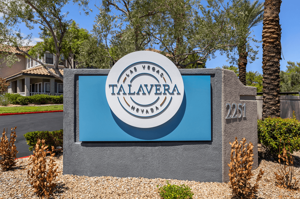 A sign for Talavera Estates in front of a house.