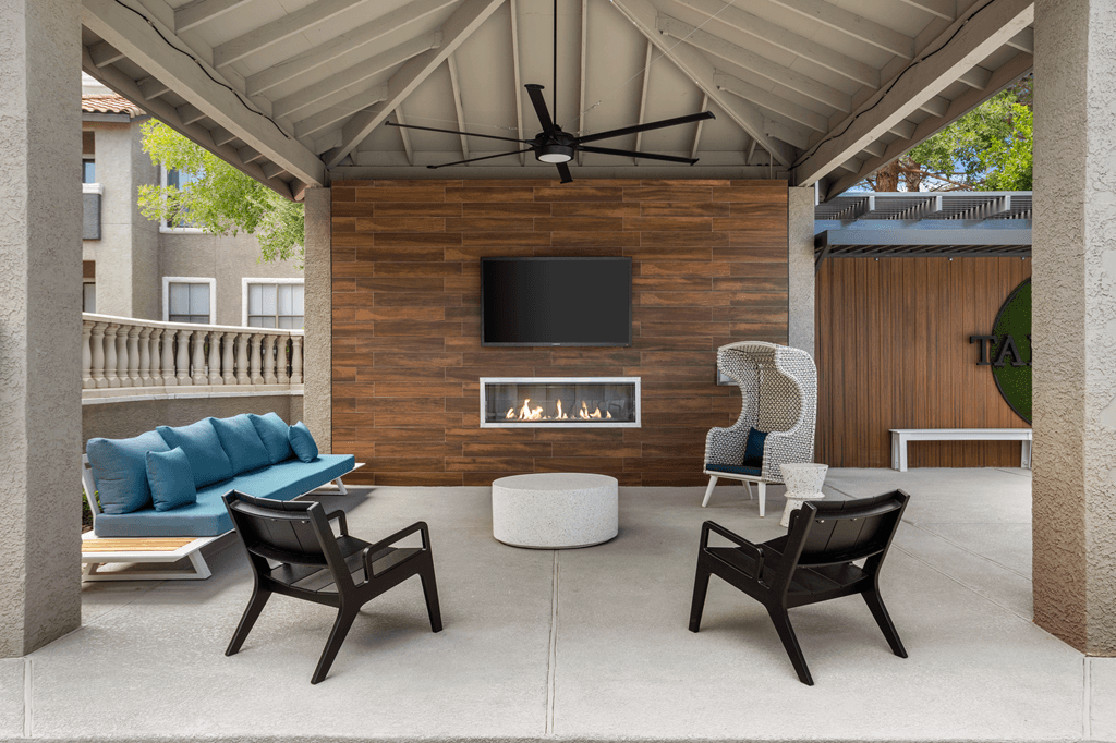 A patio with a fireplace and chairs.