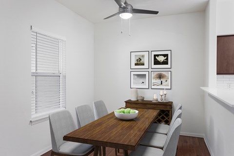 A dining room with a wooden table and chairs.