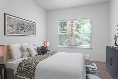 A bedroom with a large bed and a painting on the wall.
