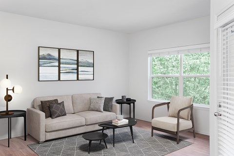 A living room with a couch, chair, and a table with a lamp on it.