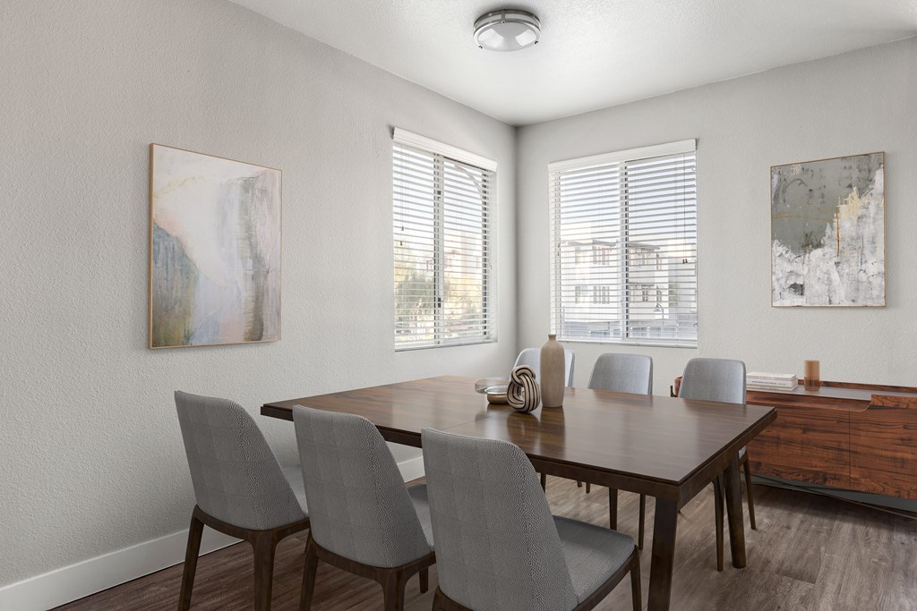 A dining room with a wooden table and grey chairs.