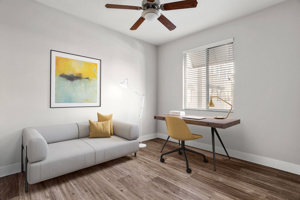 A room with a couch, chair, and painting on the wall.