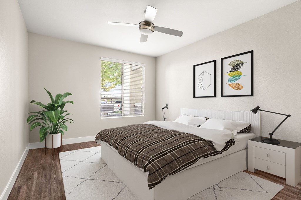 A bedroom with a bed, nightstand, and a plant.