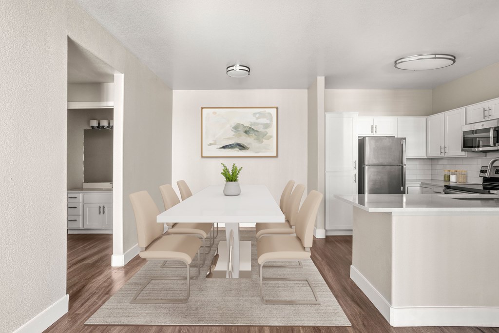 A dining room with a white table and chairs.