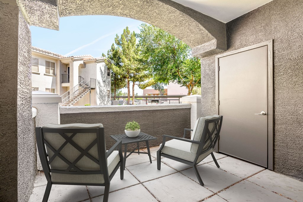 A patio with two chairs and a table.