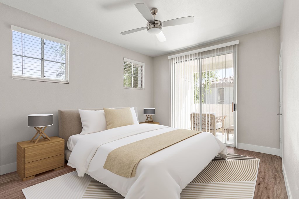 A bedroom with a large bed and a ceiling fan.