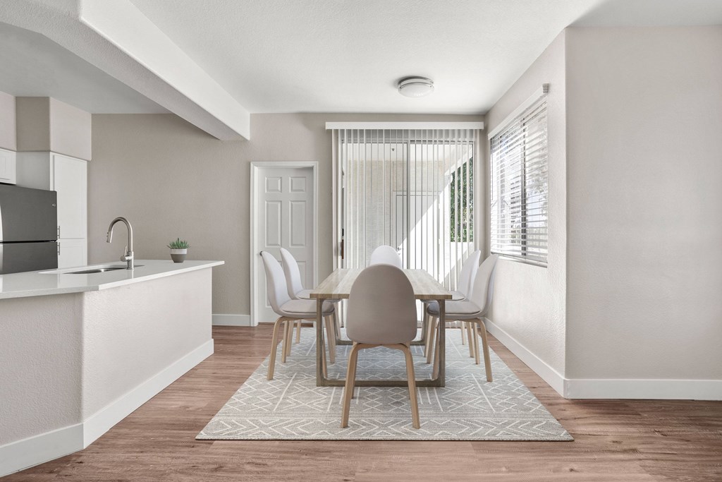 A kitchen with a dining table and chairs.