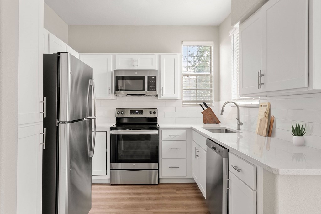 A modern kitchen with stainless steel appliances and white cabinets.