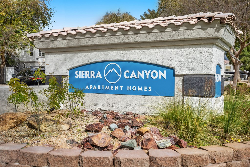 A sign for Sierra Canyon Apartment Homes is displayed in front of a building.