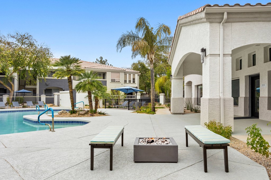 A poolside area with a fire pit and seating.
