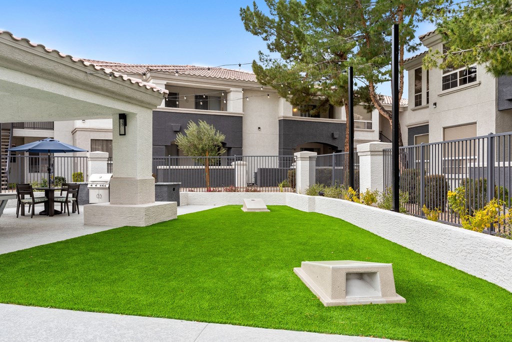 A modern backyard with a green lawn and a concrete planter.