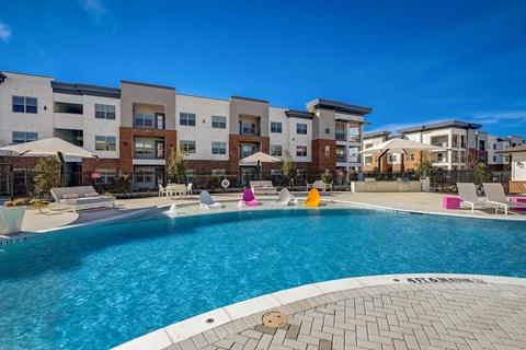 A swimming pool in front of apartment buildings.