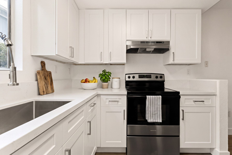 A modern kitchen with a black stove top oven.