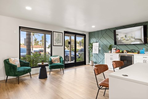 A modern living room with a green chair and a white kitchen in the background.
