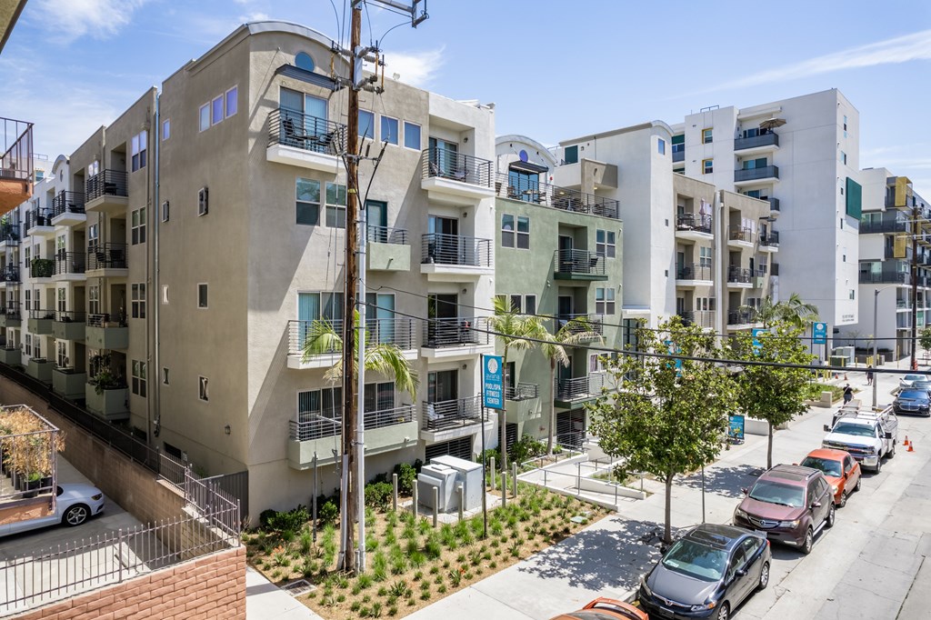 A street view of a residential area with cars parked on the side of the road.