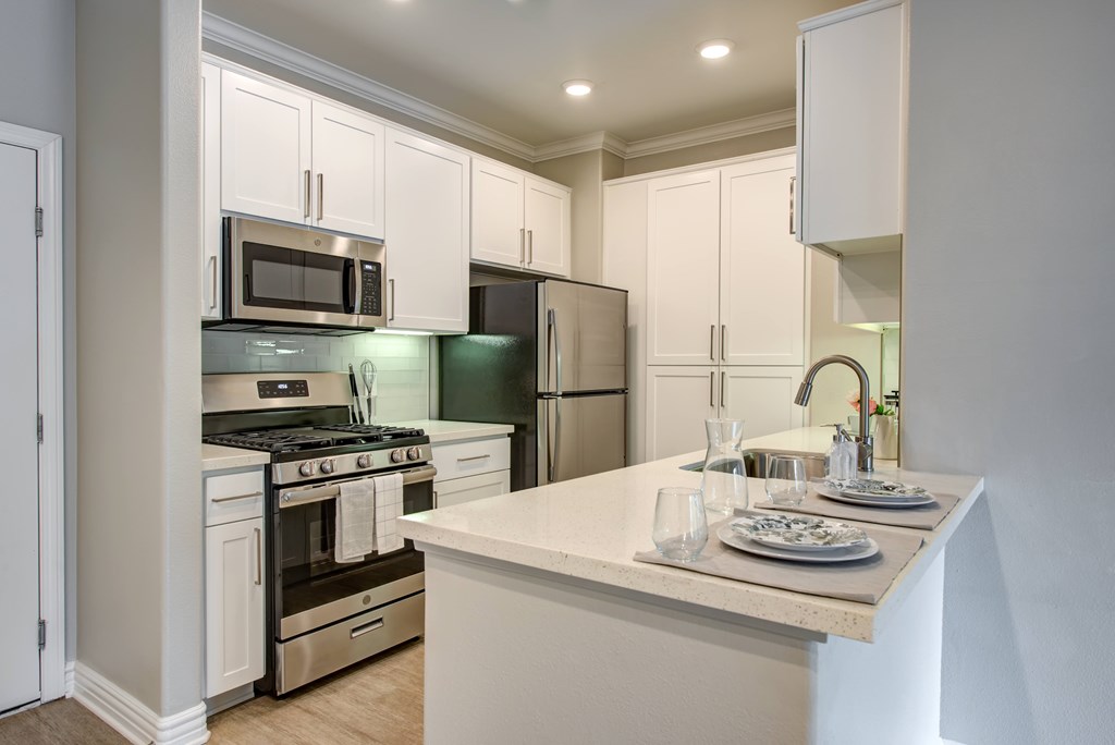 A kitchen with white cabinets and a counter.