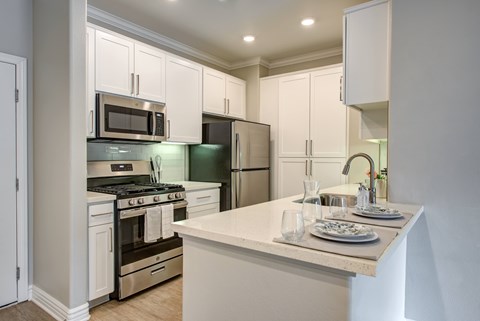 A kitchen with white cabinets and a counter.