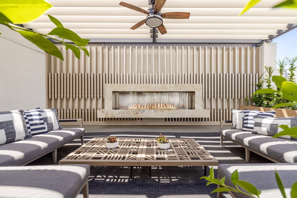 A patio with a fireplace and a table with chairs.