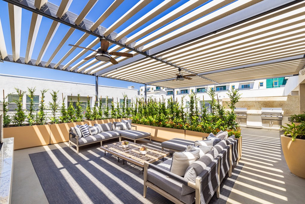 A patio with a striped rug and a striped awning.