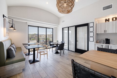 A modern living room with a green couch and a dining table with chairs.