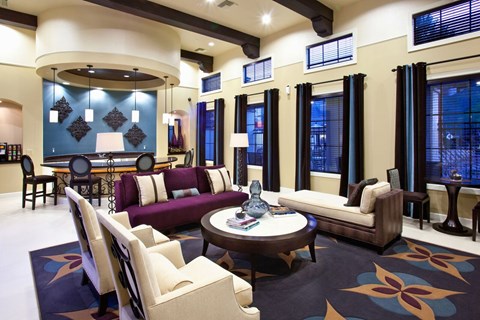 A living room with a purple couch and a coffee table.