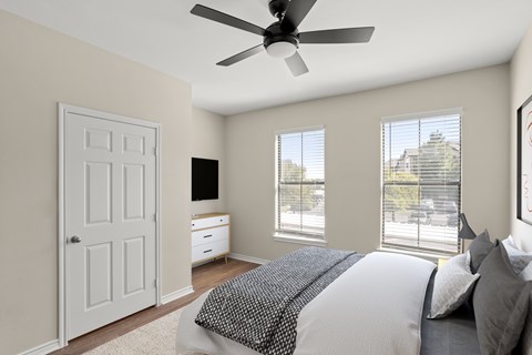 A bedroom with a large bed and a ceiling fan.