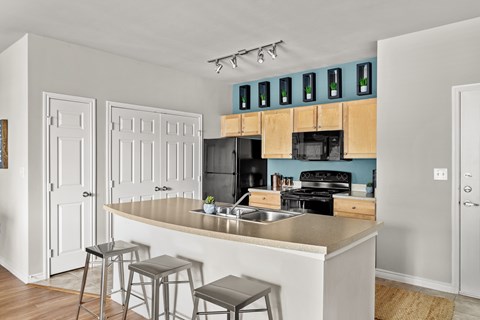A kitchen with a white counter and bar stools.