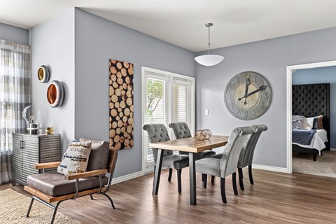 A grey and white dining room with a wooden table and chairs.