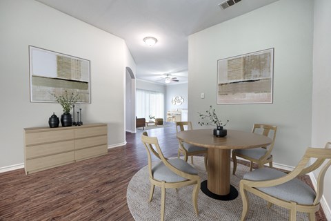 A dining room with a round table and chairs.