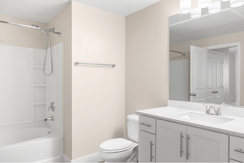 A white bathroom with a toilet, sink, and bathtub.