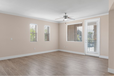 A room with a ceiling fan and a sliding glass door.