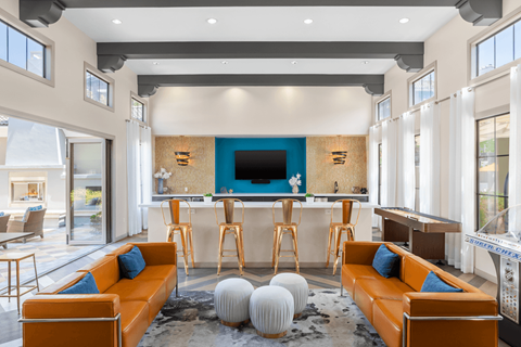 A modern living room with a blue accent wall and a bar area.