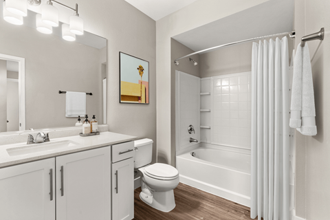 A white bathroom with a toilet, sink, and shower.