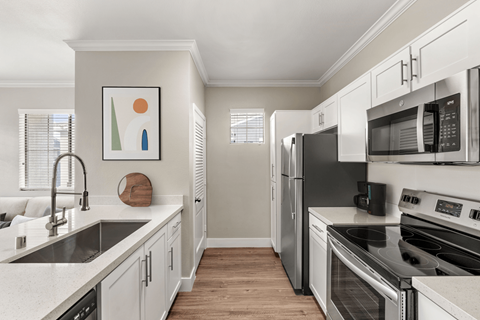 A kitchen with white cabinets and stainless steel appliances.