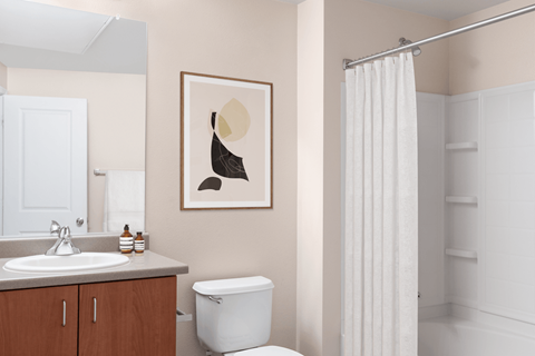 A bathroom with a toilet, sink, and shower.