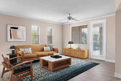 A living room with a brown couch, a coffee table, and a ceiling fan.