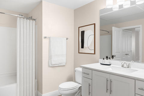 A white toilet sits in a bathroom next to a white sink.