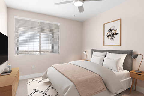 A bedroom with a large bed and a ceiling fan.