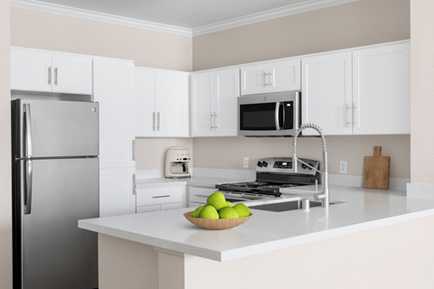 A kitchen with a refrigerator, microwave, and stove.