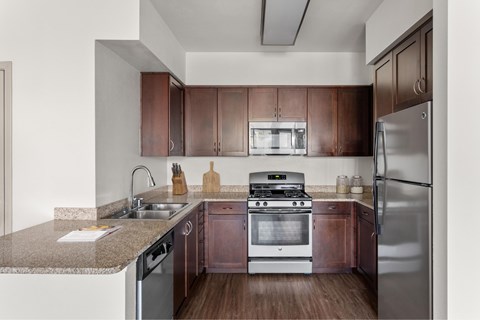 A kitchen with brown cabinets and stainless steel appliances.