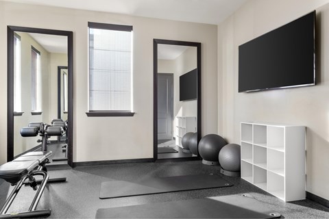 A gym with a mirror, a bench, and a ball.