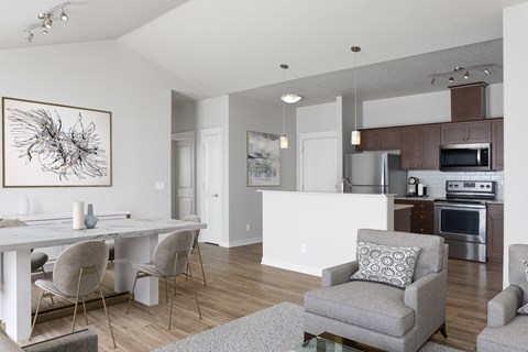 A modern dining room with a white table and grey chairs.