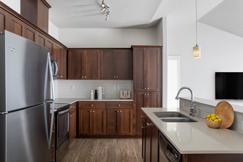 A modern kitchen with wooden cabinets and stainless steel appliances.