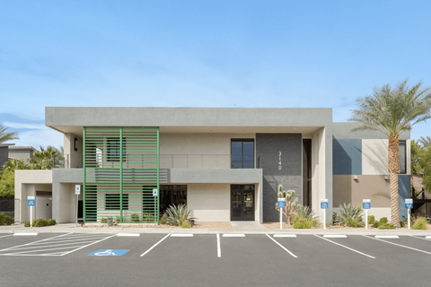 A modern building with a parking lot in front of it.