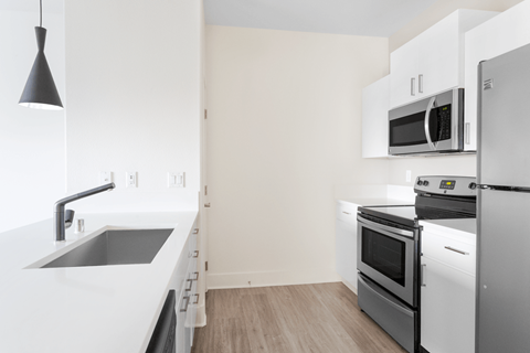 A kitchen with white appliances and a white counter top.