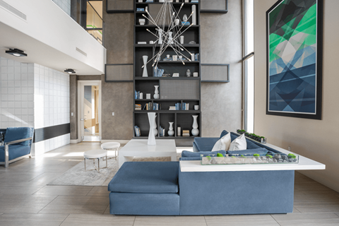 A modern living room with a blue sofa and a white coffee table.