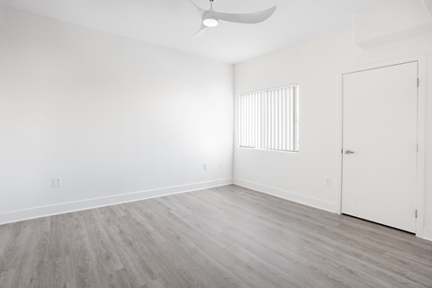 A room with a ceiling fan and a door.