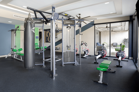 A gym with a punching bag, weight machines and exercise bikes.