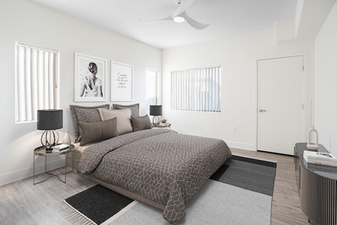 A bedroom with a large bed and a ceiling fan.